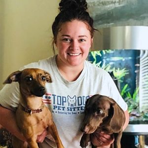 Leah the pet sitter holding two small dogs